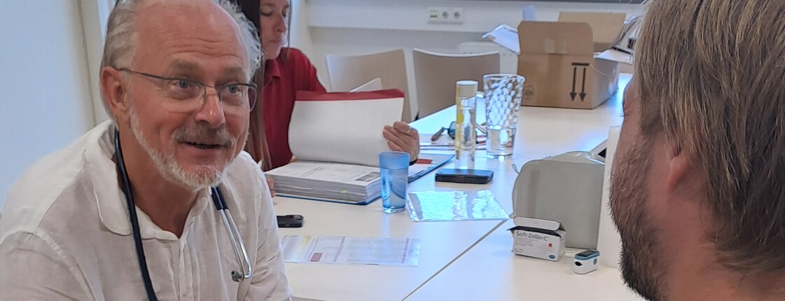 Ein Arzt in der Virgilambulanz betreut einen Patienten
