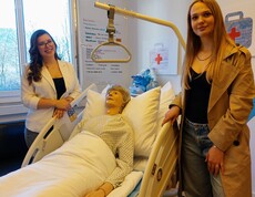 Zwei Schülerinnen über an einer Pflegepuppe