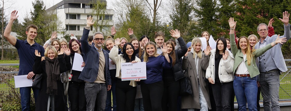 Eine Gruppe Schüler*innen jubelt über die Spendensumme