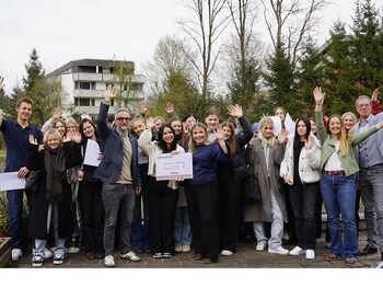 Eine Gruppe Schüler*innen jubelt über die Spendensumme