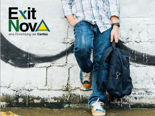 Ein Jugendlicher mit Rucksack lehnt an einer Hausmauer