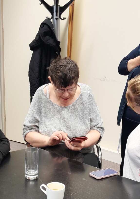 Junge Frauen erklären einer älteren das Smarphone