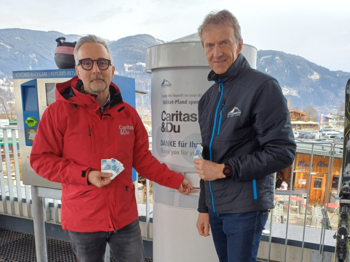 Zwei Männer vor einer Spendenbox