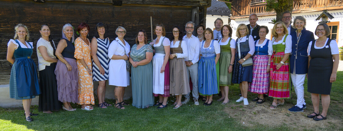 Eine Gruppe Frauen und Männer stehen auf einer grünen Wiese
