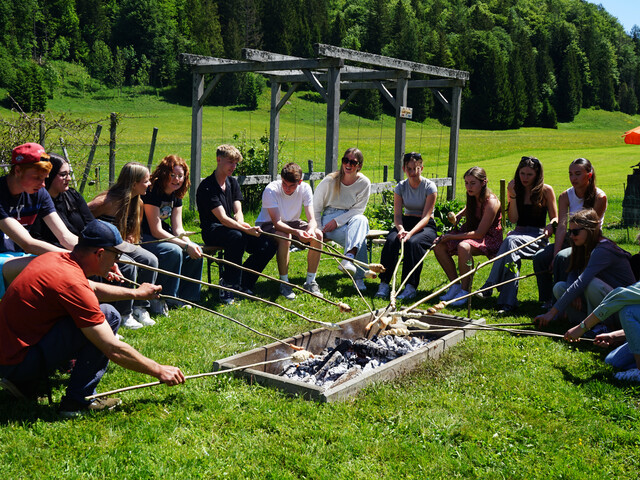 Junge Menschen grillen in der Wiese