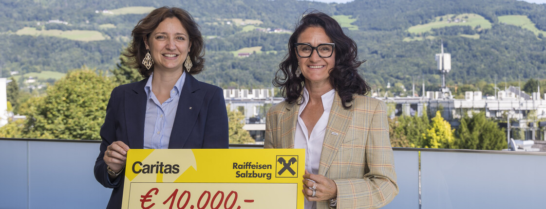 Zwei Frauen mit einem Spendenscheck