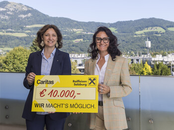 Zwei Frauen mit einem Spendenscheck