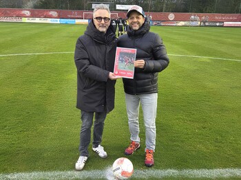 Zwei Männer stehen auf einem Fußballfeld