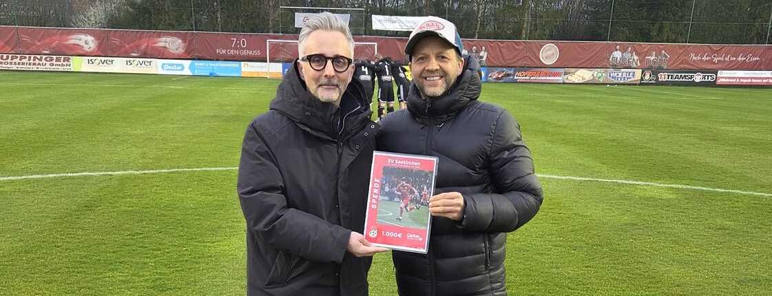 Zwei Männer stehen auf einem Fußballfeld