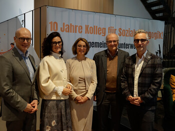 Bild v.l.n.r.: Landesrat Wolfgang Fürweger, Caritasdirektorin Andrea Schmid,
Johanna Harb, Leiterin des Kollegs für Sozialpädagogik, Festredner Reinhard Haller, Psychiater und Autor und Caritasdirektor Kurt Sonneck. 5 Personen stehen vor einerm Jubiläumsplakat