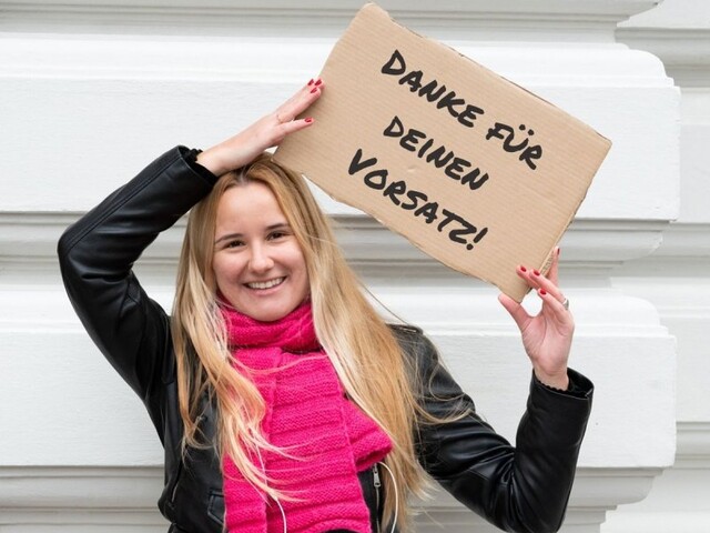 Frau mit Schild zum Neujahrsvorsatz