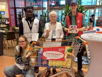 Vier Helfende mit Einkaufswagen bei Caritas-Lebensmittelsammlung im Markt
