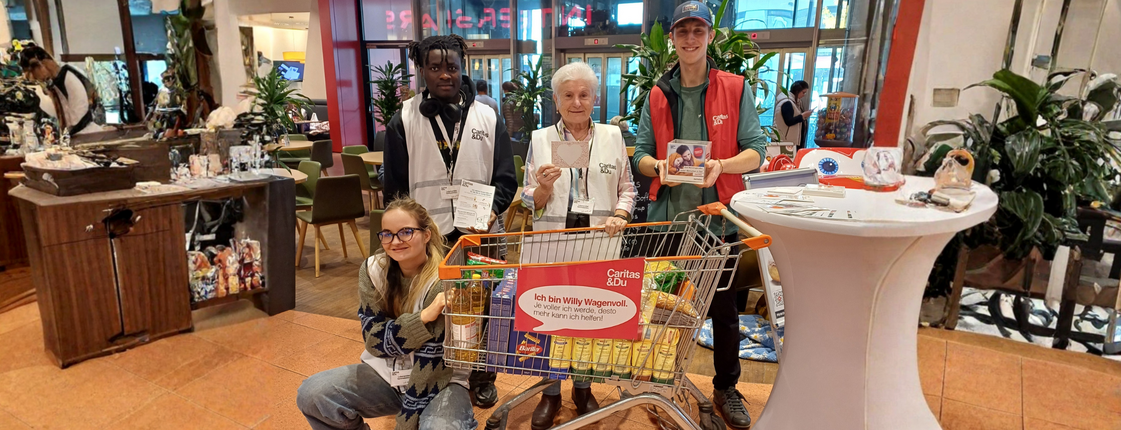 Vier Helfende mit Einkaufswagen bei Caritas-Lebensmittelsammlung im Markt
