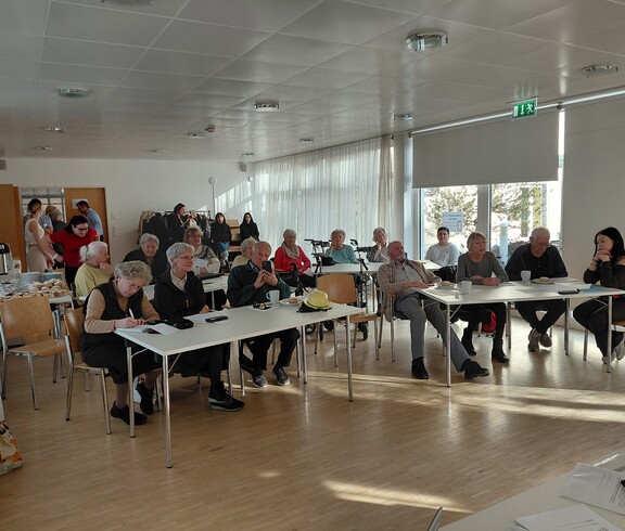 Eine Gruppe Senior*innen bei einem Vortrag