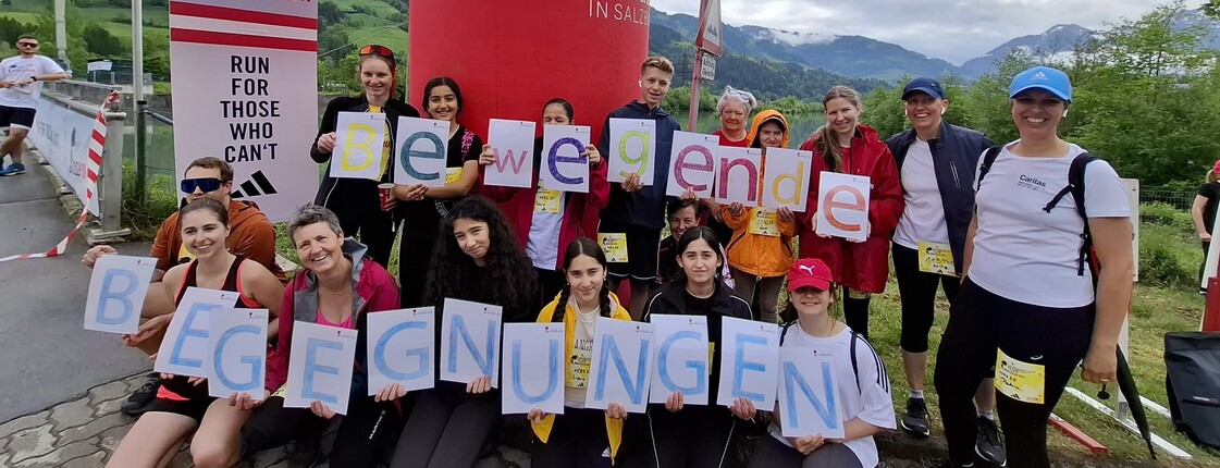 Eine Gruppe von Läufern hält die Buchstaben von bewegende Begegnungen in der Hand