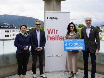 4 Personen halten einen Spendengutschein mit 15.000 Euro in der Hand