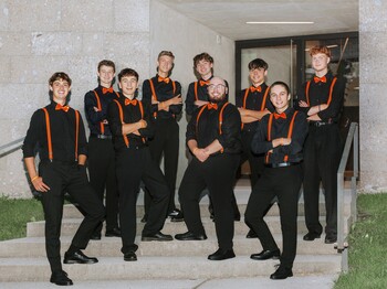 Neun junge Männer stehen auf einer Treppe