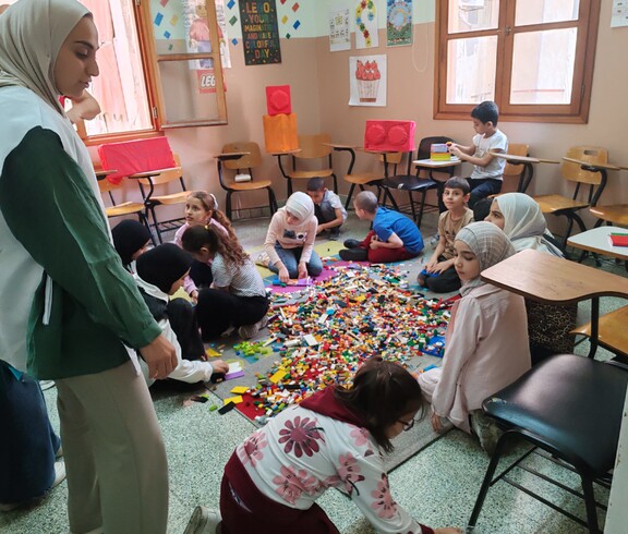 Kinder spielen mit vielen Legosteinen