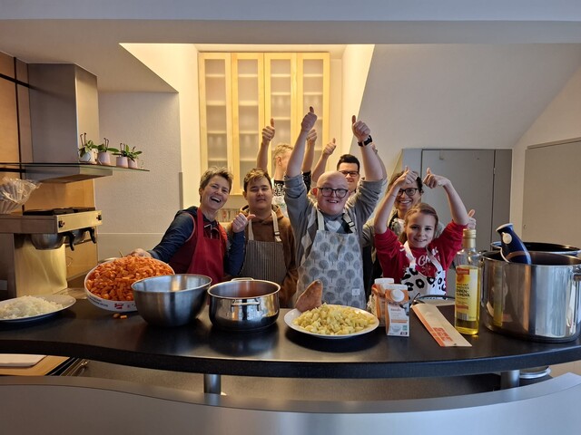 Eine Kochgruppe freut sich über ein gelungenes Menü