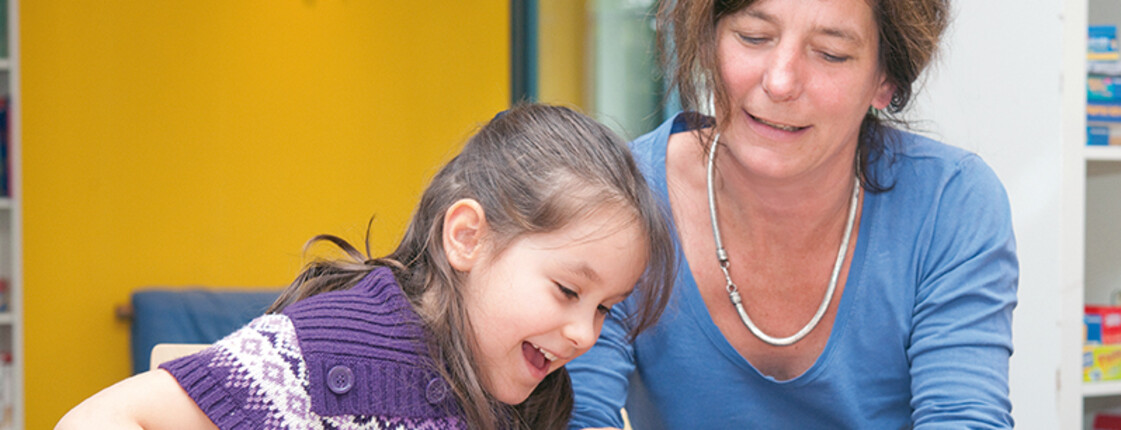 Mädchen und freiwillige Mitarbeiterin im Lerncafé