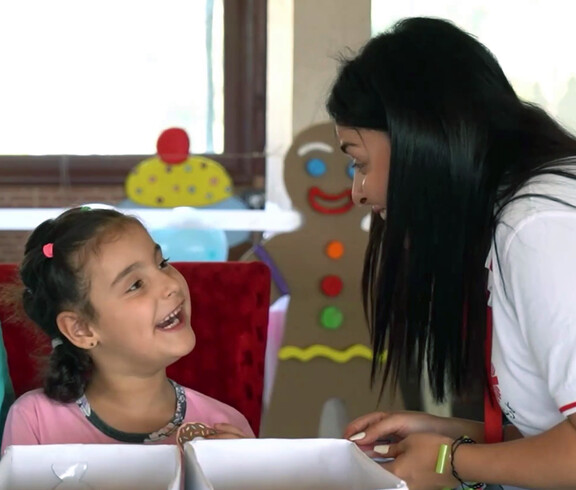 Eine syrisches Mädchen mit einer Betreuerin