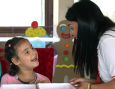 Eine syrisches Mädchen mit einer Betreuerin