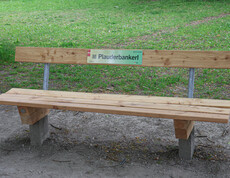 Eine Parkbank mit einer Plakette