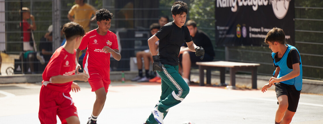 Vier Kinder spielen Fußball im Freien