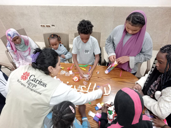 Eine Mitarbeiterin von Caritas Ägypten mit sudanesischen Flüchtlingskindern