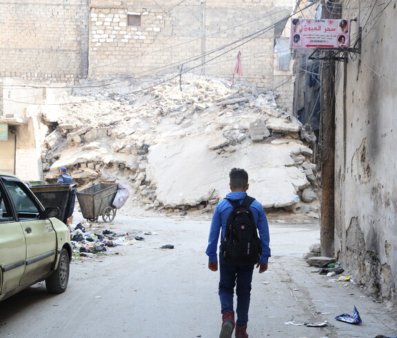 Ein Junge in einer zerbombten Stadt