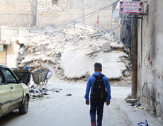 Ein Junge in einer zerbombten Stadt