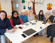 Sechs Menschen sitzen an einem Tisch