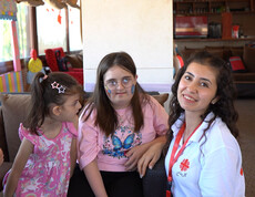 Eine syrische Mutter mit ihrer Tochter und einer Betreuerin