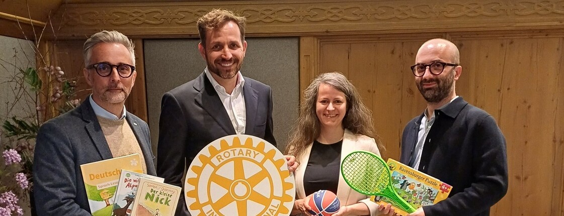 3 Männer und eine Frau präsentieren eine Spende