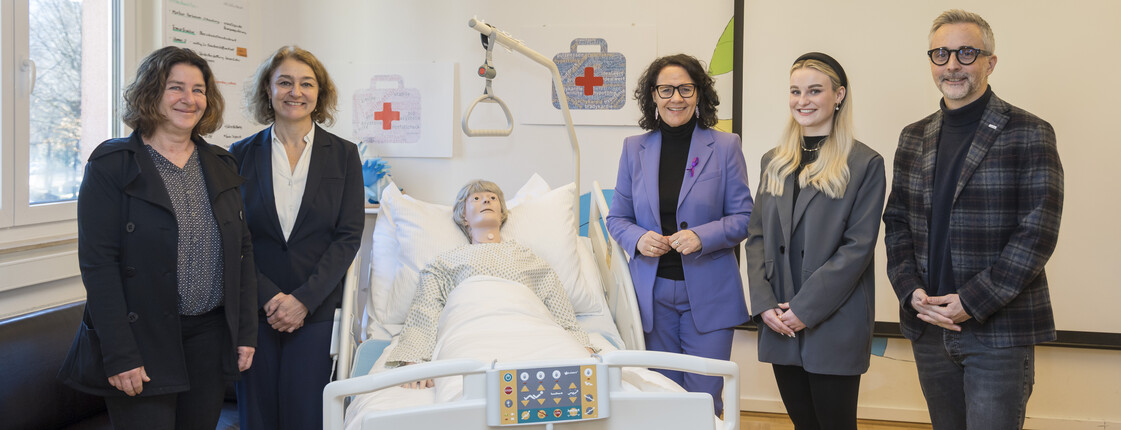 Vier Frauen und ein Mann stehen um ein Pflegebett