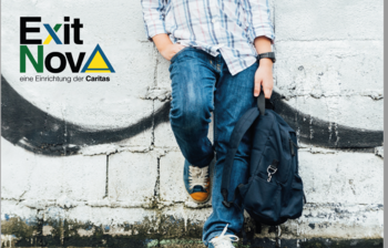 Ein Jugendlicher mit Rucksack lehnt an einer Hausmauer