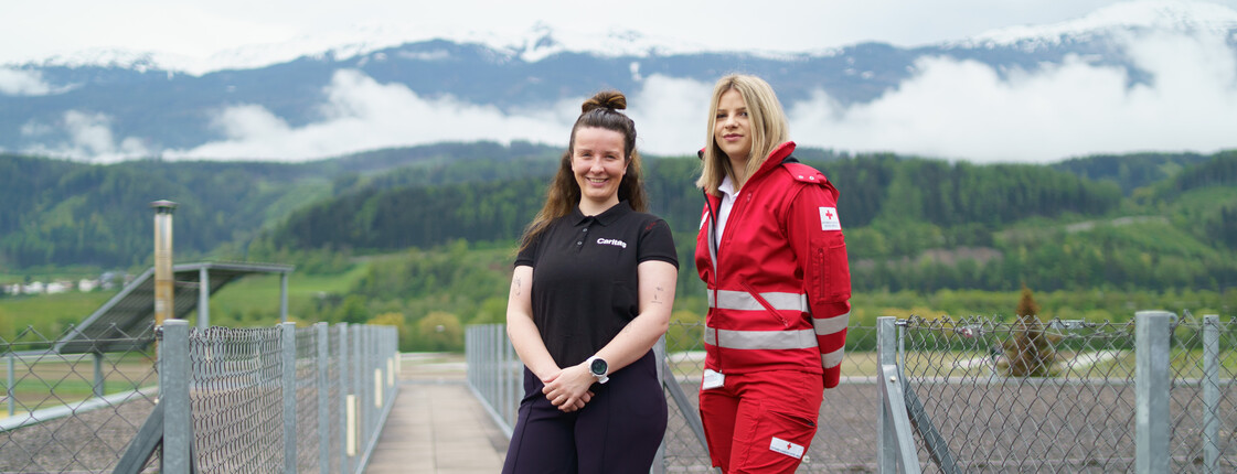 Portrait zweier Frauen mit Bergkulisse im Hintergrund.