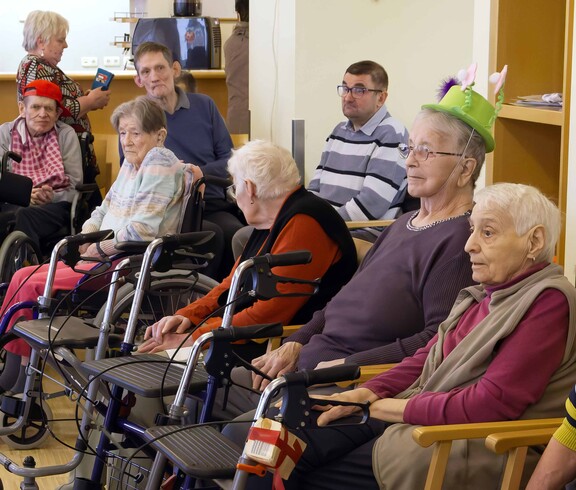 Acht ältere Bewohner hören Musik