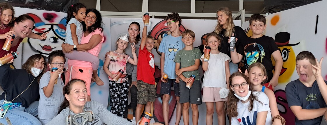 Eine Gruppe Kinder mit selbst gemalten Bildern