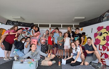 Eine Gruppe Kinder mit selbst gemalten Bildern