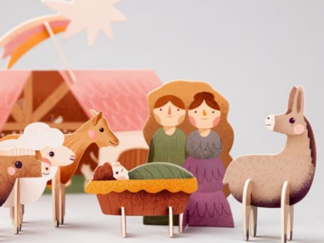 Bunte Krippenfiguren mit Maria, Josef, Jesuskind und Tieren vor Stall