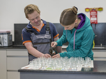 Ein Mann und eine Frau bei der Teelichterproduktion