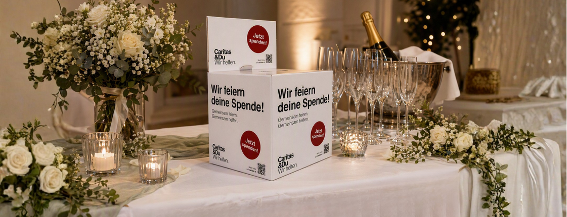 Eine Spendenbox der Caritas auf einem Gabentisch