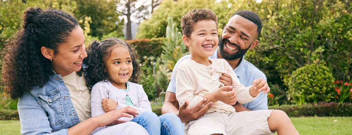 Eine Familie sitzt auf einer Picknickdecke