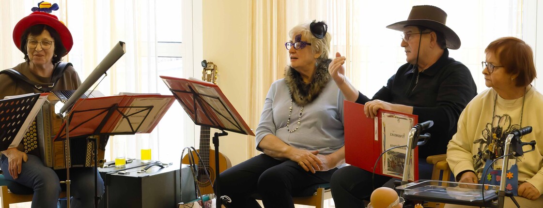 Zwei Musikerinnen, ein Musiker und eine Zuhörerin sitzen im Halbkreis