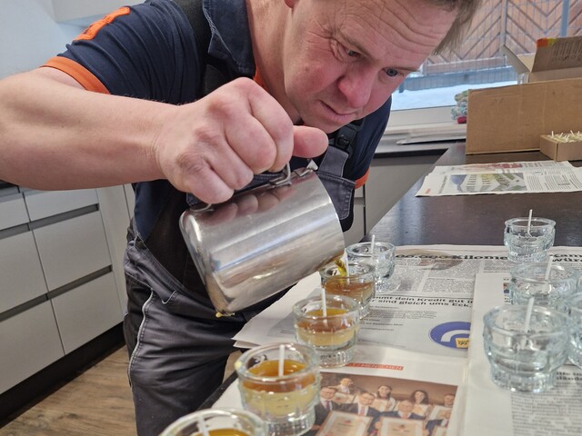 Ein Mann gießt Wachs in Teelichtergläser