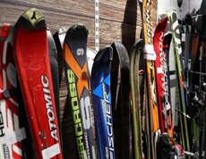 Skier und Skistöcke sind in einer Reihe nebeneinander aufgestellt
