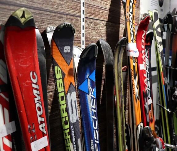 Skier und Skistöcke sind in einer Reihe nebeneinander aufgestellt
