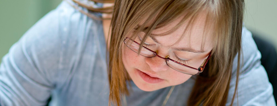 Ein Mädchen mit Trisomie 21 beim Malen