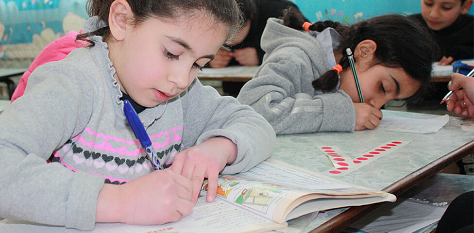 Mehrere Kinder in einem Klassenzimmer beim Schreiben in der Schule der Barmherzigen Schwestern in Broumana, Libanon
